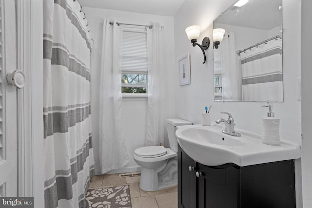 bathroom featuring tile patterned flooring, vanity, curtained shower, and toilet