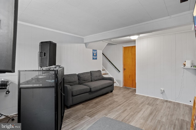 living room featuring ornamental molding, hardwood / wood-style floors, and wooden walls