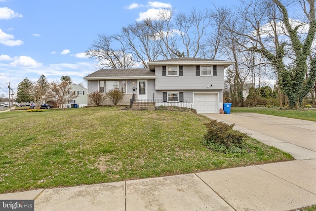 tri-level home featuring a garage and a front lawn