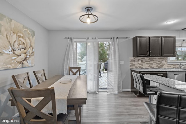 dining area with sink, light hardwood / wood-style floors, and a wealth of natural light