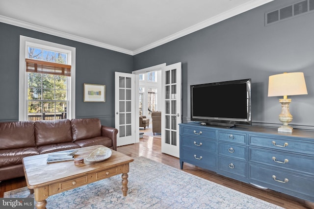 living room with crown molding, dark hardwood / wood-style floors, and french doors