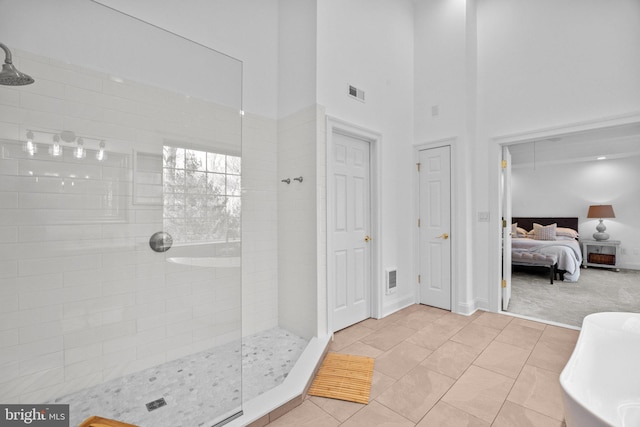 bathroom with tile patterned flooring, separate shower and tub, and a high ceiling