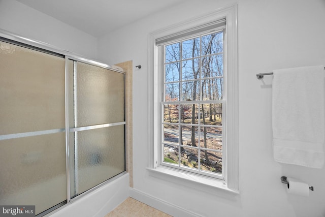 bathroom with bath / shower combo with glass door