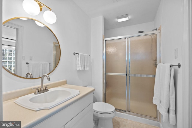 bathroom with a shower with door, vanity, and toilet