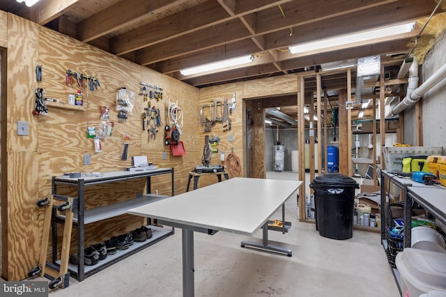 basement featuring water heater and a workshop area