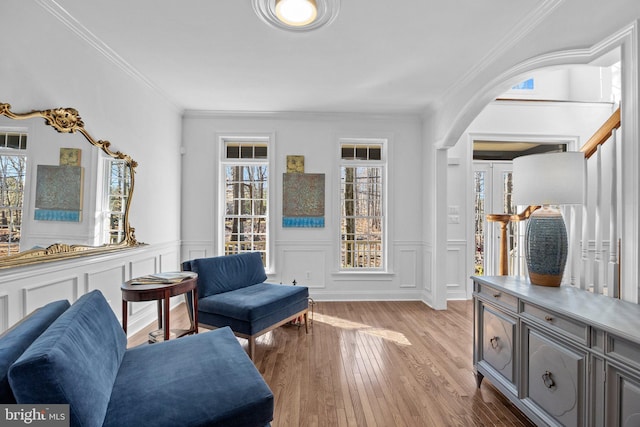 living area with ornamental molding and light hardwood / wood-style flooring