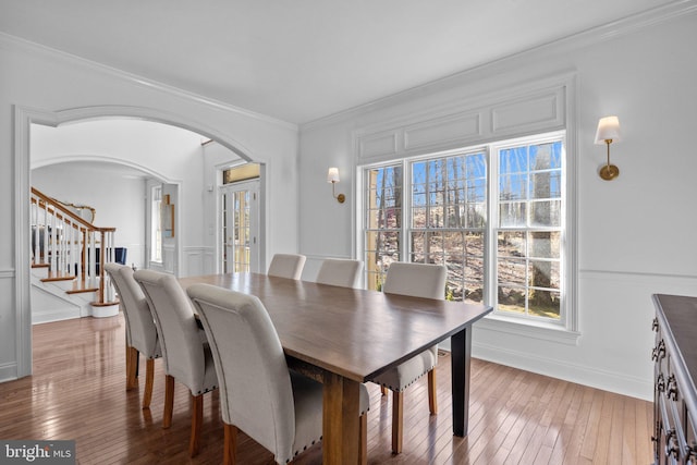 dining area with wood-type flooring and ornamental molding