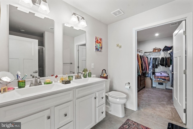 bathroom with vanity, toilet, a shower with door, and tile patterned flooring