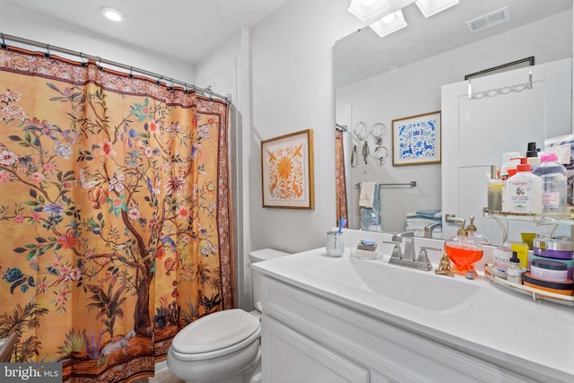 bathroom with vanity, toilet, and walk in shower