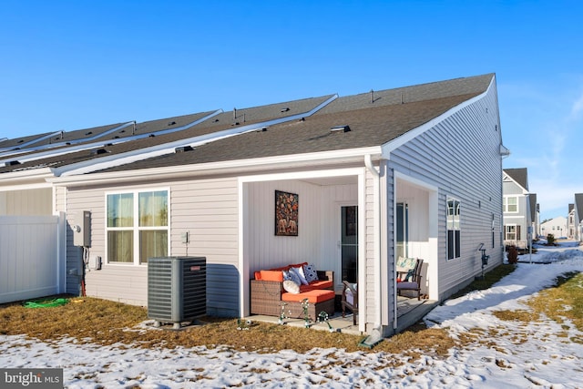 snow covered property featuring an outdoor living space and central air condition unit