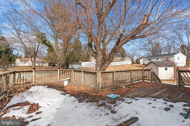 snow covered deck with a shed