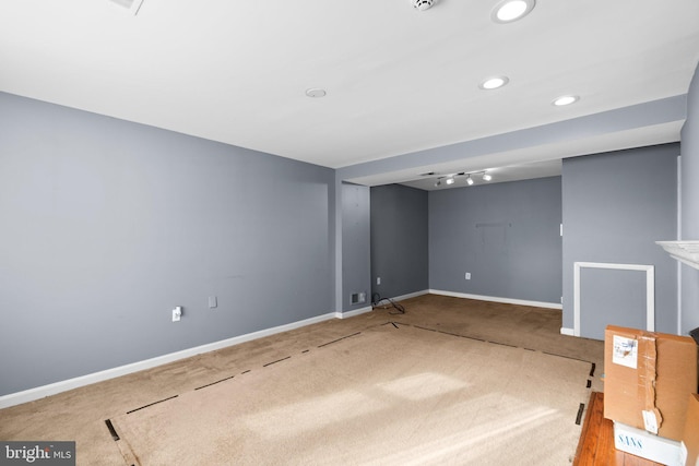 basement with carpet floors and track lighting