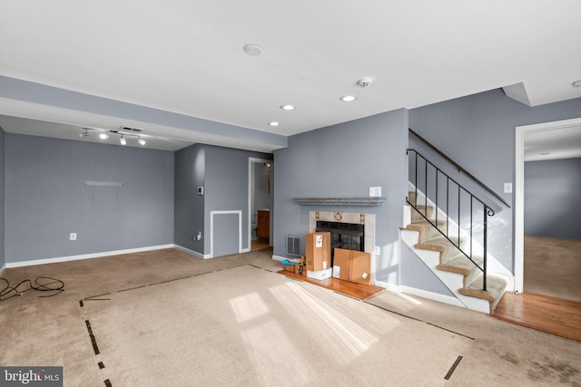 unfurnished living room featuring carpet floors and track lighting