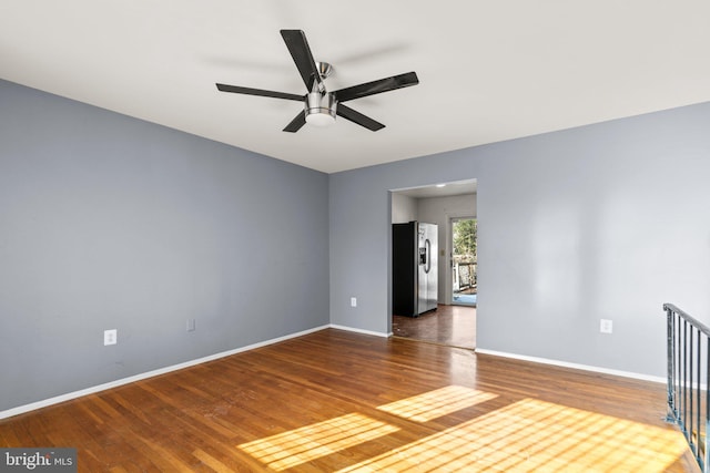 unfurnished room with ceiling fan and dark hardwood / wood-style flooring