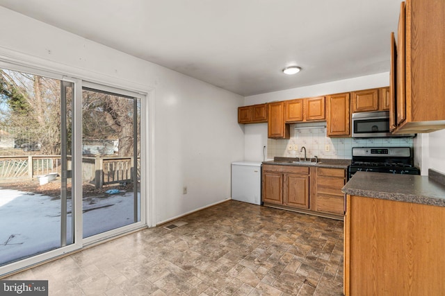 kitchen with backsplash, sink, and gas range oven