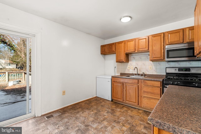 kitchen with appliances with stainless steel finishes, sink, and backsplash