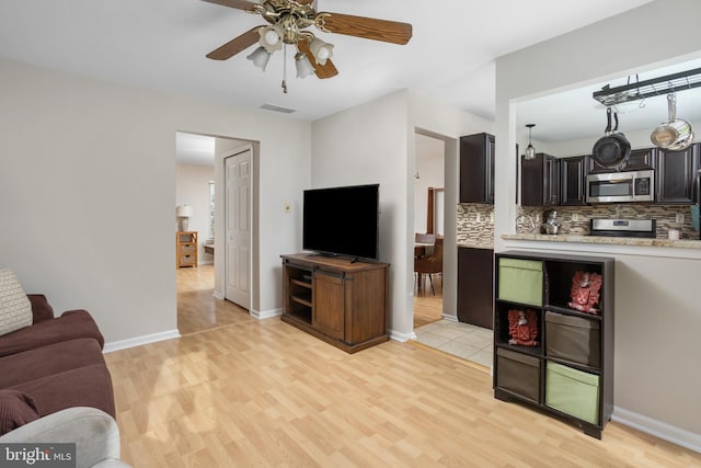 living room with ceiling fan and light hardwood / wood-style floors