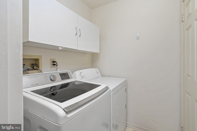 laundry area with cabinets and washing machine and clothes dryer