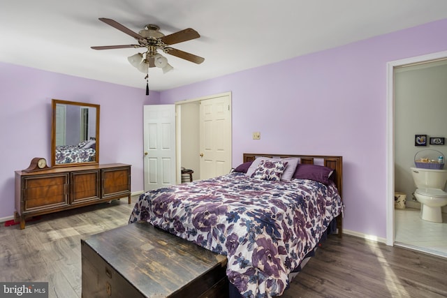 bedroom featuring connected bathroom, dark wood-type flooring, and ceiling fan