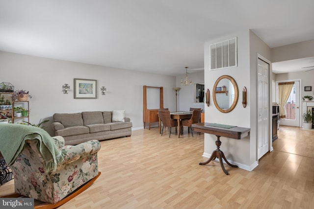 living room featuring an inviting chandelier and light hardwood / wood-style floors