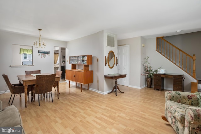 dining space featuring a notable chandelier and light wood-type flooring