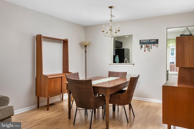 dining space featuring a notable chandelier and light hardwood / wood-style floors