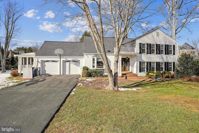 view of front of house with a garage, a sunroom, and a front lawn