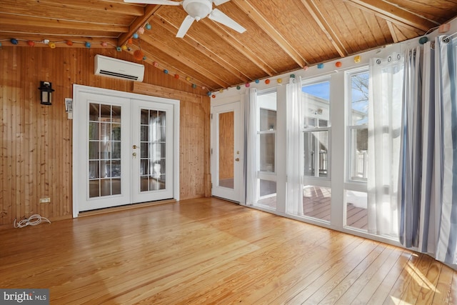 unfurnished sunroom with a wall mounted air conditioner, vaulted ceiling with beams, ceiling fan, wooden ceiling, and french doors