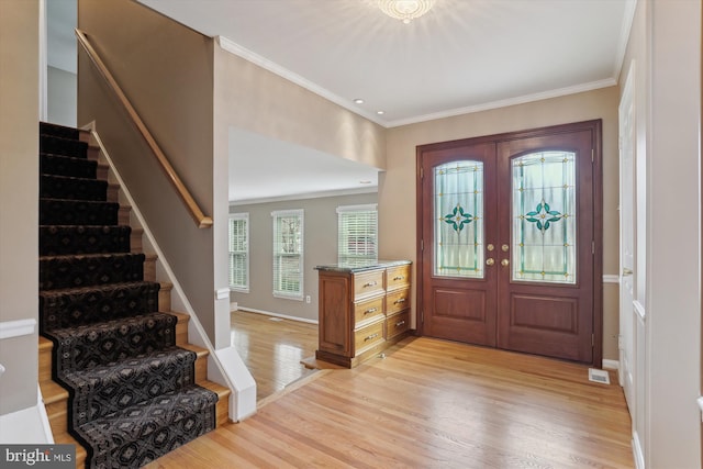 entryway featuring french doors, ornamental molding, and light hardwood / wood-style floors