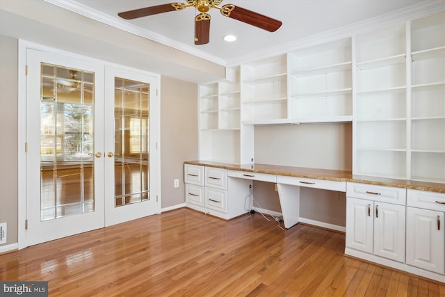 unfurnished office with crown molding, built in desk, light hardwood / wood-style floors, and french doors