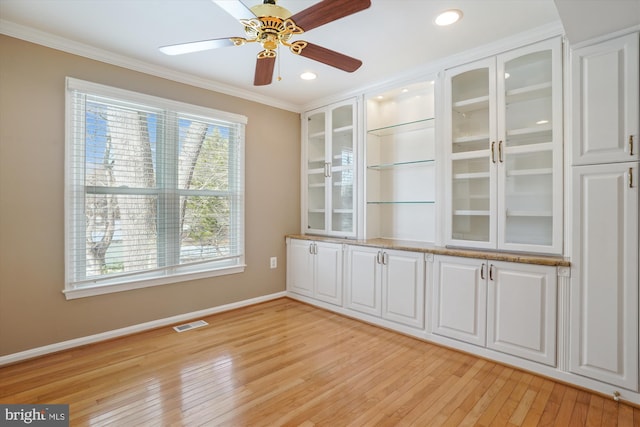 spare room featuring light hardwood / wood-style flooring, ornamental molding, and ceiling fan