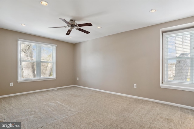 carpeted empty room with a wealth of natural light and ceiling fan