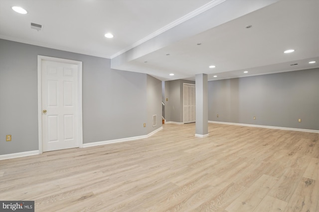 basement with ornamental molding and light wood-type flooring