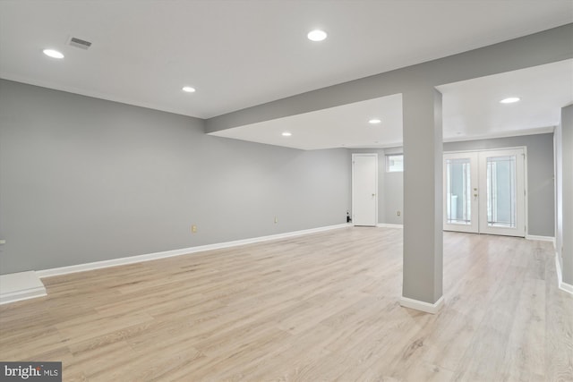 basement with french doors and light wood-type flooring