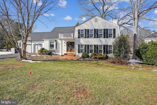 view of front of home with a garage, a front lawn, and a balcony