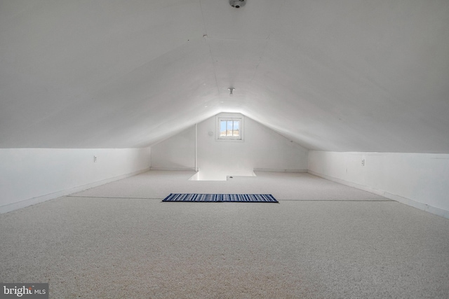 bonus room featuring vaulted ceiling and light carpet