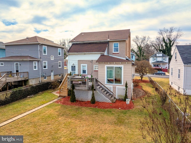 back of property with a deck and a lawn