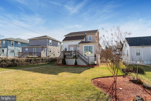 rear view of property featuring a yard and a deck