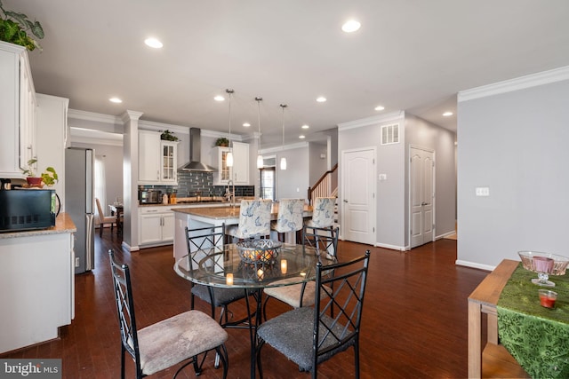 dining space featuring visible vents, ornamental molding, stairway, recessed lighting, and dark wood finished floors