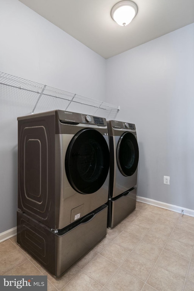 laundry room with baseboards, tile patterned flooring, laundry area, and independent washer and dryer