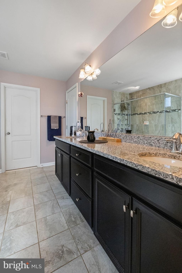 bathroom with double vanity, visible vents, a shower stall, a sink, and marble finish floor