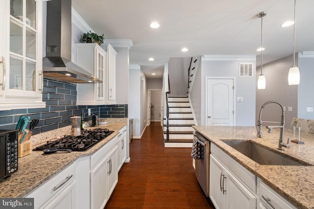kitchen with black gas stovetop, a sink, wall chimney exhaust hood, visible vents, and dark wood-style floors