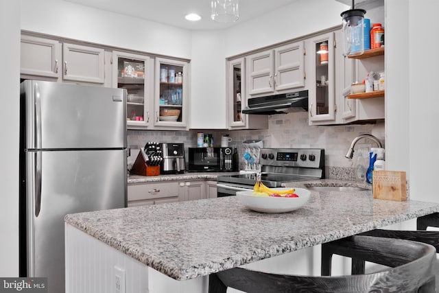 kitchen with sink, hanging light fixtures, kitchen peninsula, and appliances with stainless steel finishes