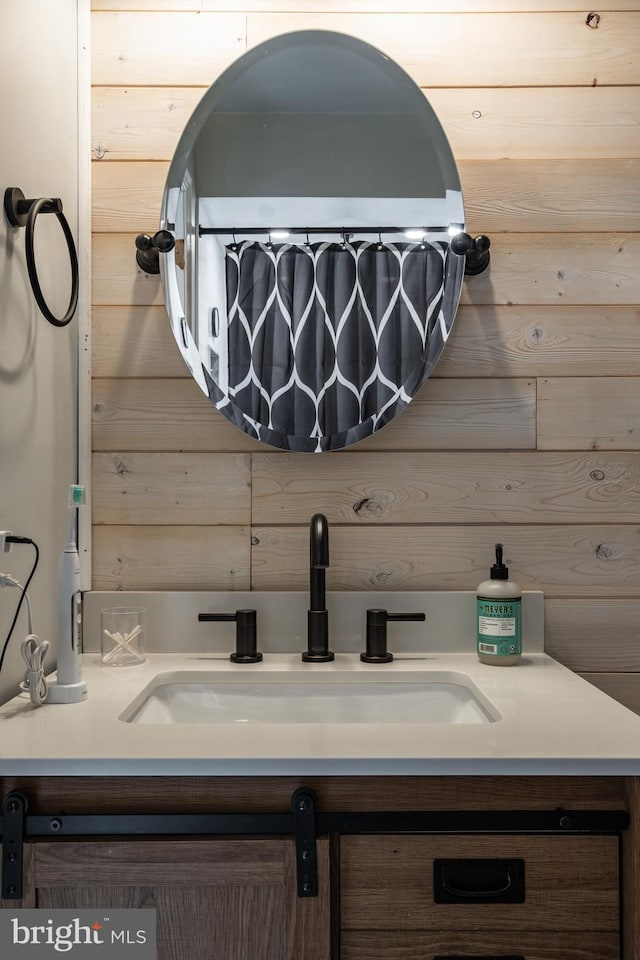 bathroom with vanity and wood walls