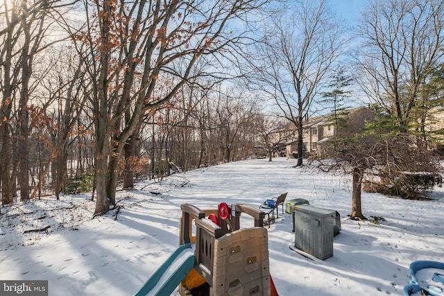 yard covered in snow with a playground