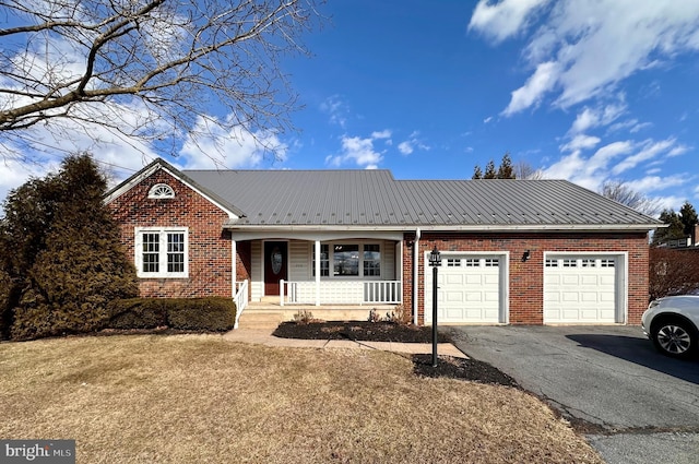 view of front of home with a garage, covered porch, and a front lawn