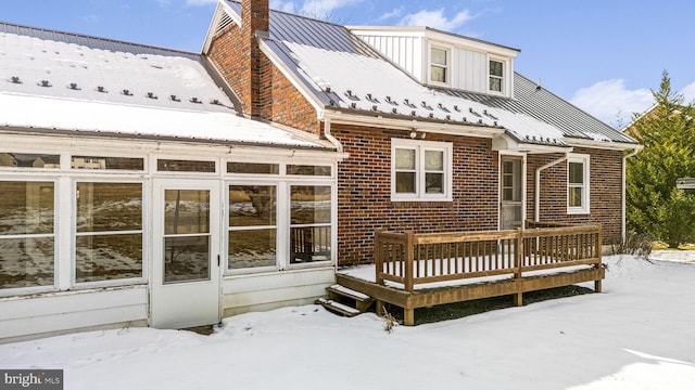 snow covered rear of property with a wooden deck