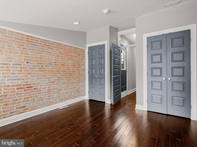 2437 Fleet St, Baltimore, MD 21224 - spare room featuring brick wall, baseboards, hardwood / wood-style floors, and a smoke detector