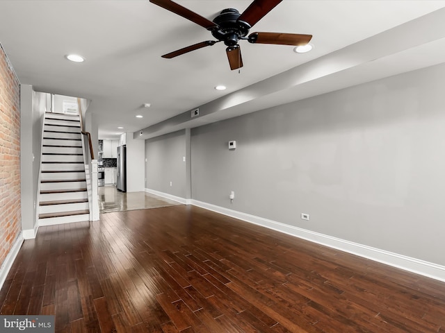 2437 Fleet St, Baltimore, MD 21224 - unfurnished living room with baseboards, ceiling fan, hardwood / wood-style floors, stairway, and brick wall