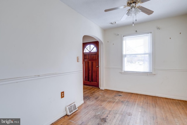 foyer entrance with ceiling fan, a textured ceiling, and light wood-type flooring